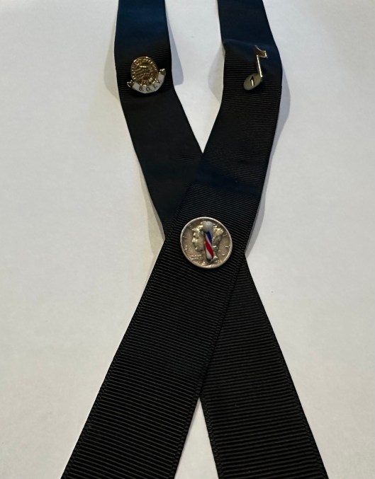 black ribbon with three pins, all earned from my chorus activities